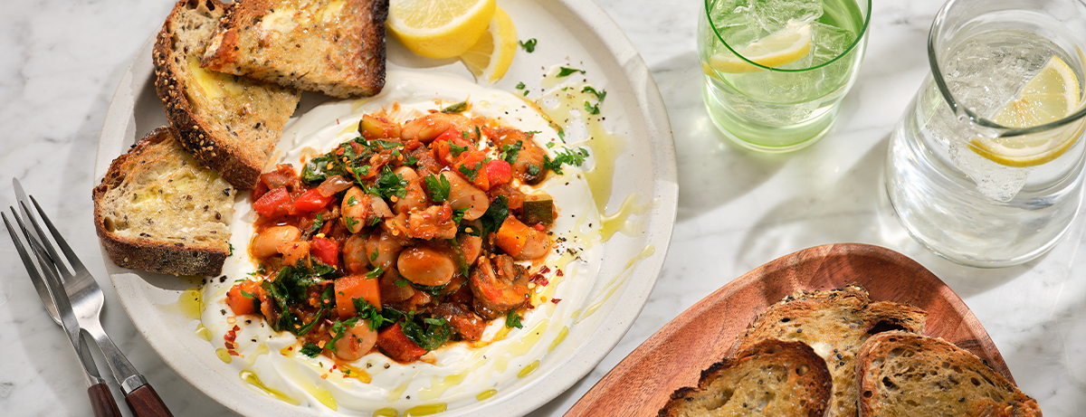 Bean strew with toasted bread on white plate