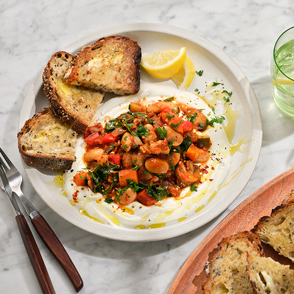 Bean strew with toasted bread on white plate