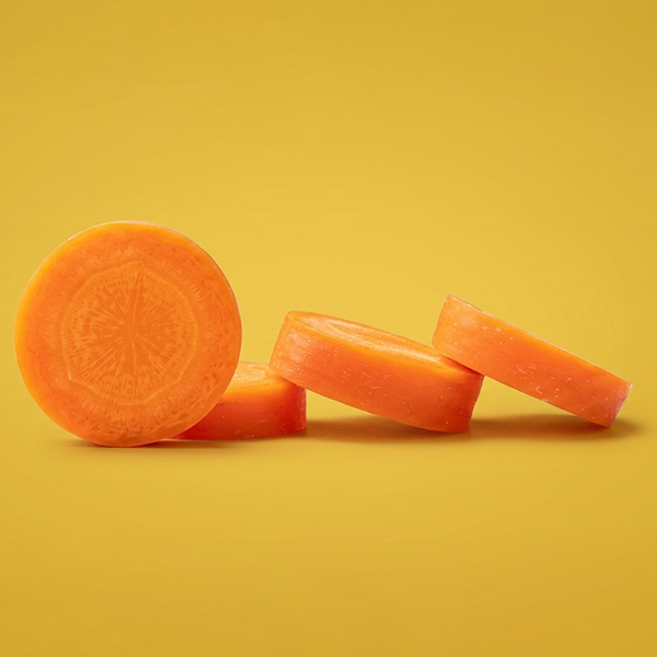 Carrot slices on yellow background