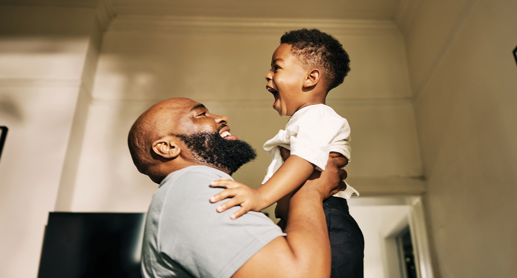 Father holding smiling child in the air