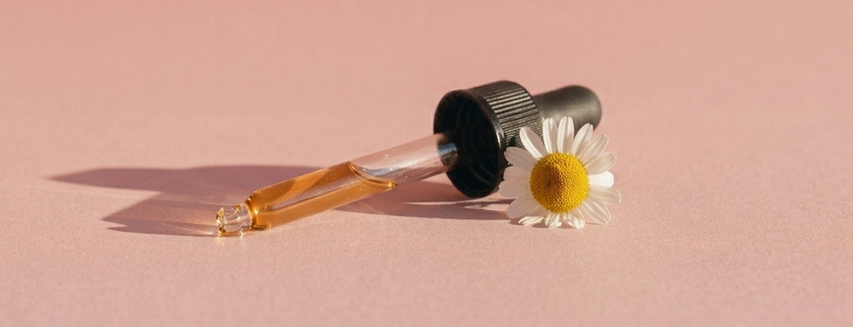 Chamomile pipette and flower on pink background