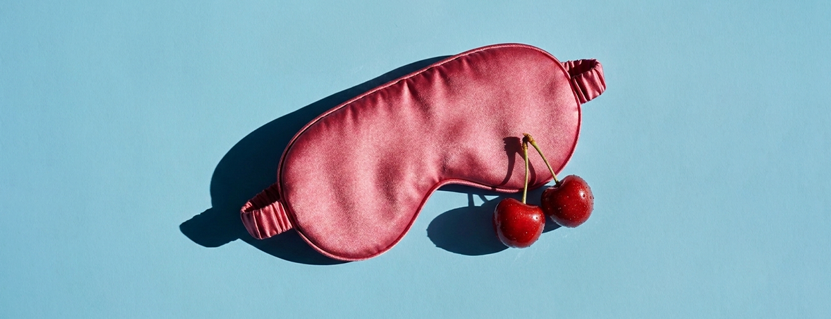 Eye mask and cherries on a blue background