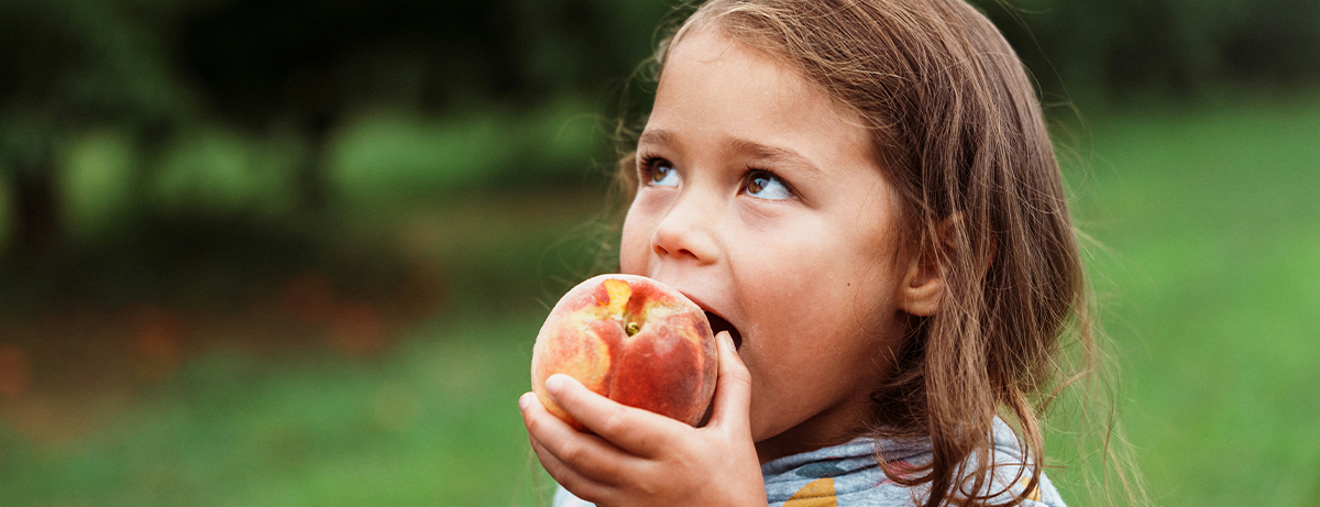 girl eating an apple in the park