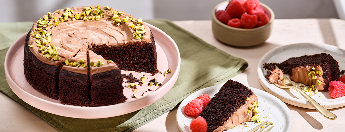 Chocolate olive oil cake on worktop with a slice taken out