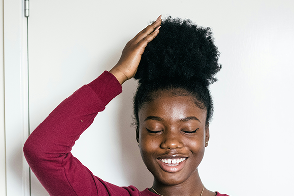 Female with coily hair in a bun