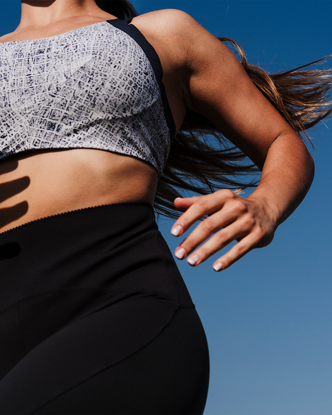 Female running outdoors with blue sky behind