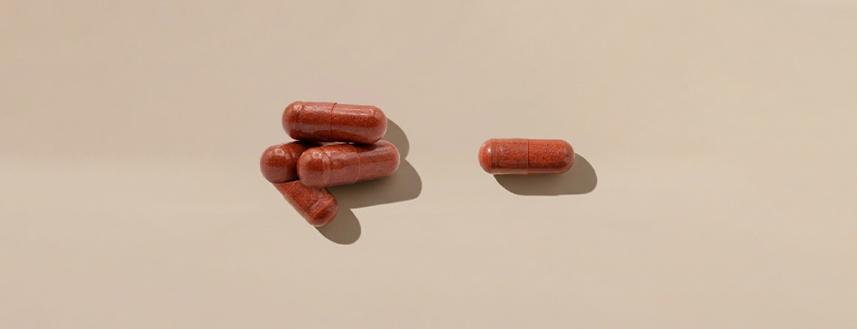 5 red supplements on a beige background