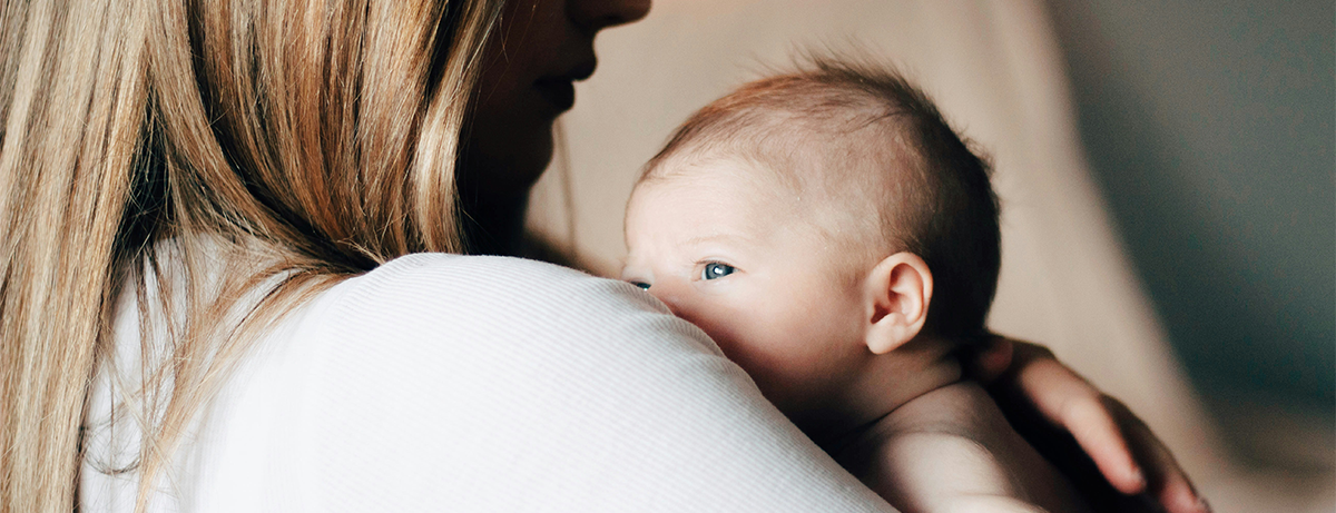 Mother holding baby in home setting