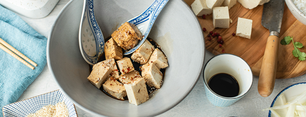 Tofu and soy sauce on a wooden board
