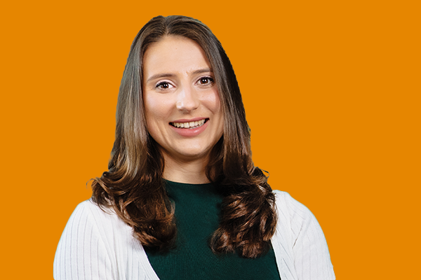 Expert advisor smiling at the camera. In front of orange background