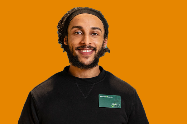 Expert advisor smiling at the camera. In front of orange background