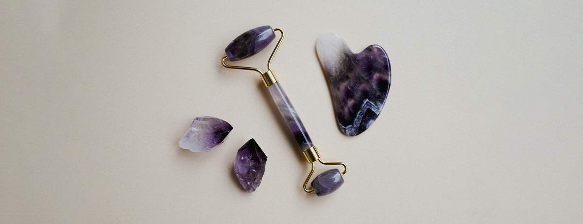 Jade roller and gua sha on a white background