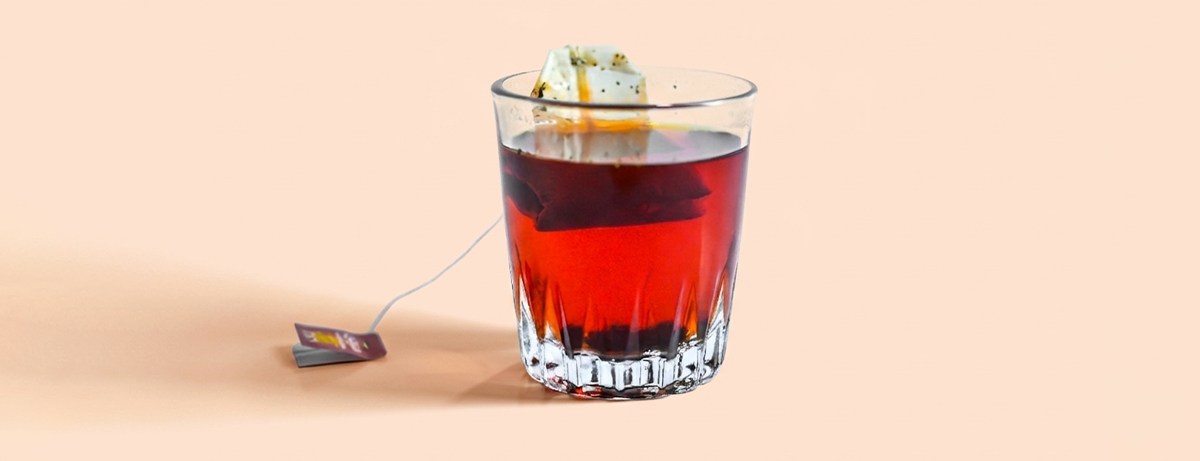 Glass of black tea on a peach background