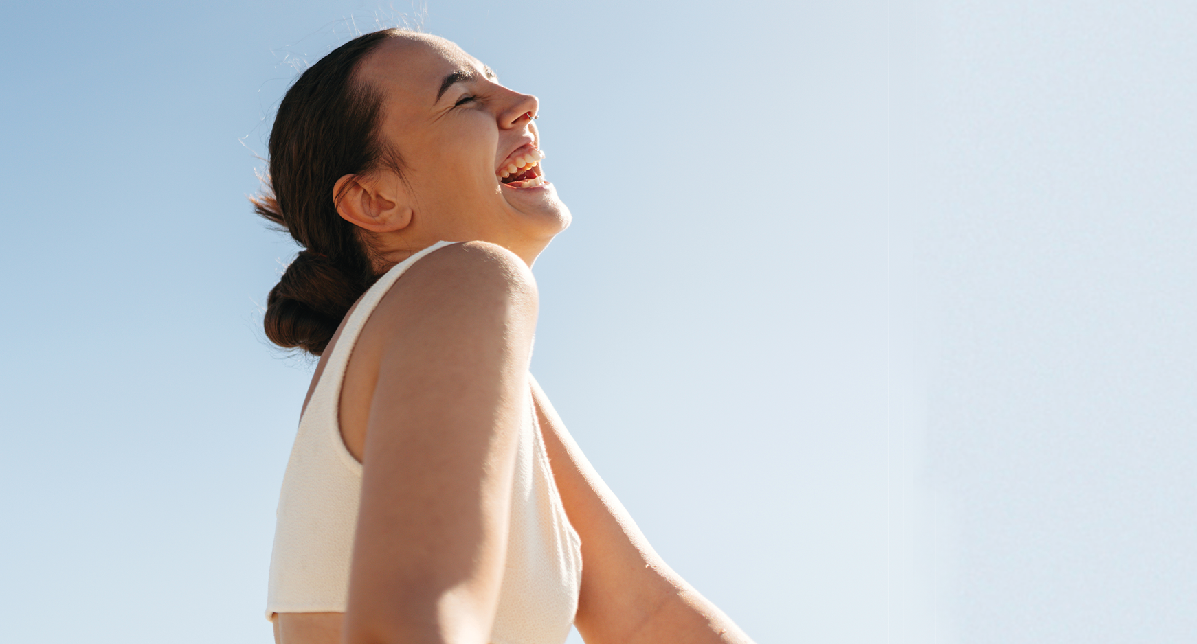 Female laughing with blue sky in background
