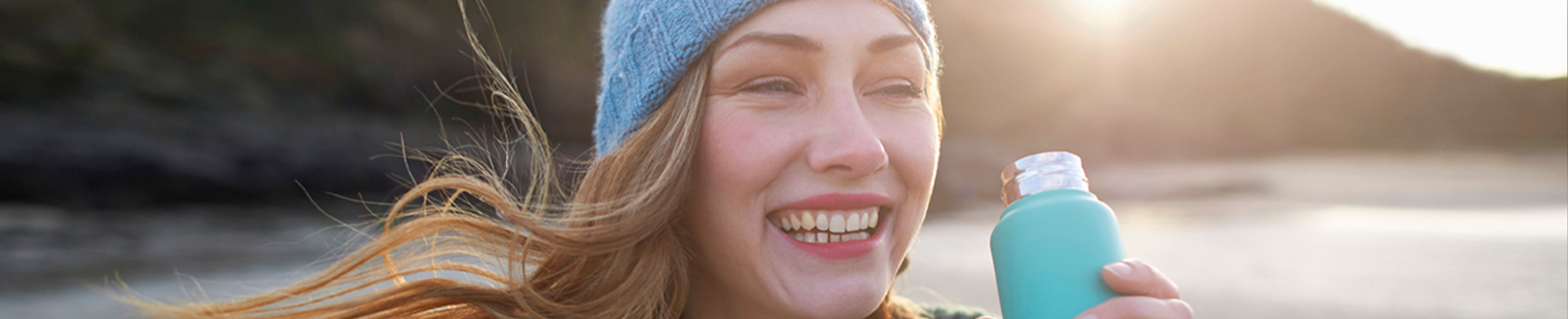 Female with water bottle and winter hat standing outside