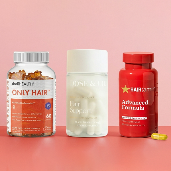 Selection of hair vitamins on red background