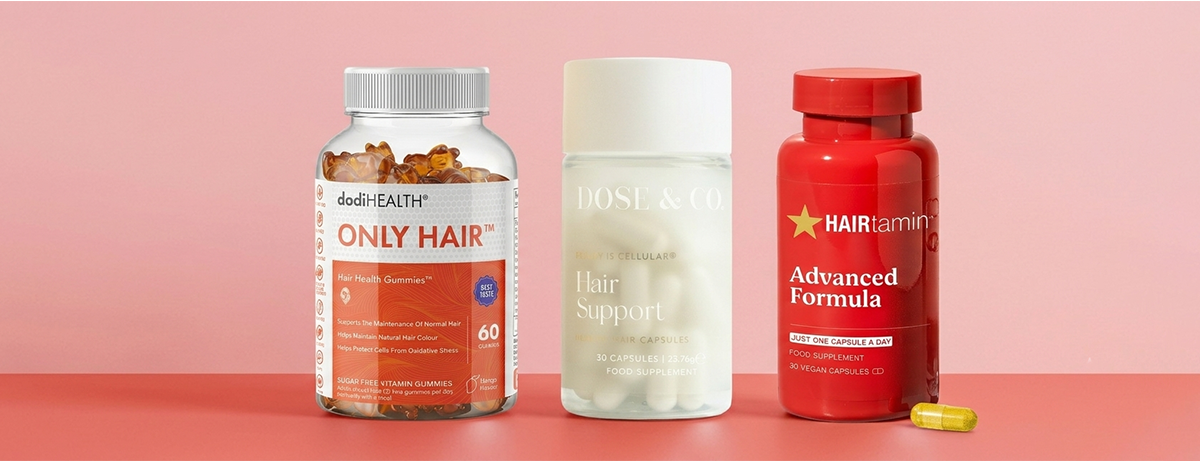 Selection of hair vitamins on red background