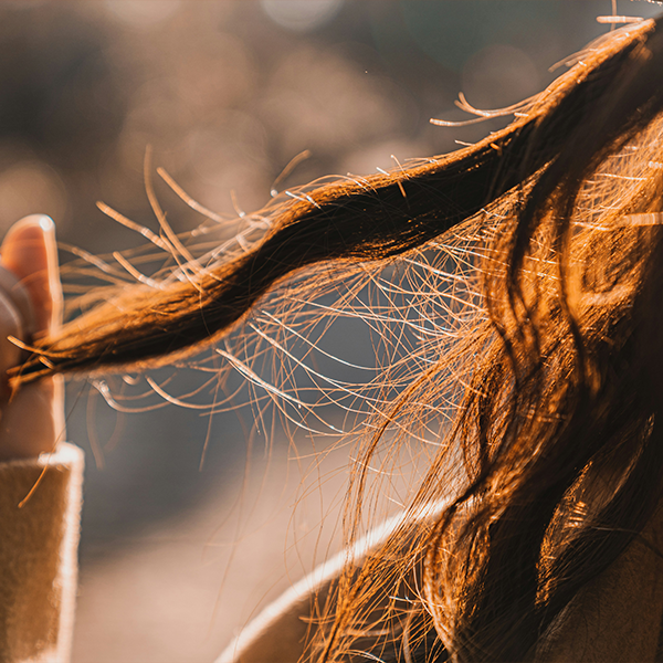 Hand holding hair in outdoor setting