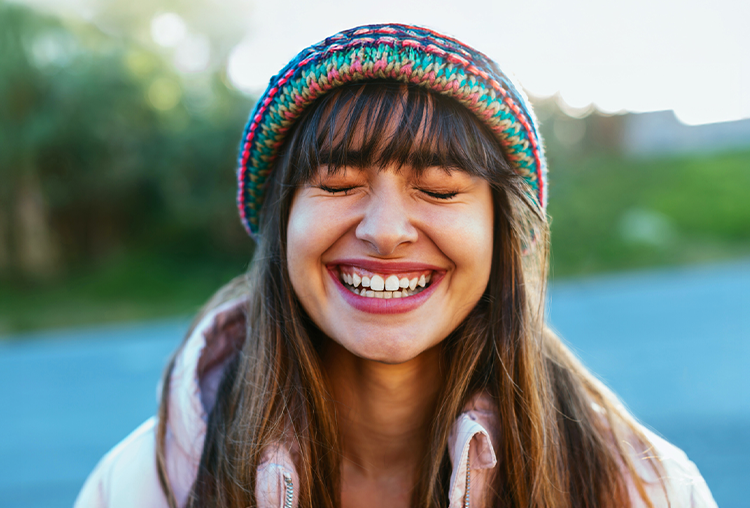Female in winter hat smiling at the camera