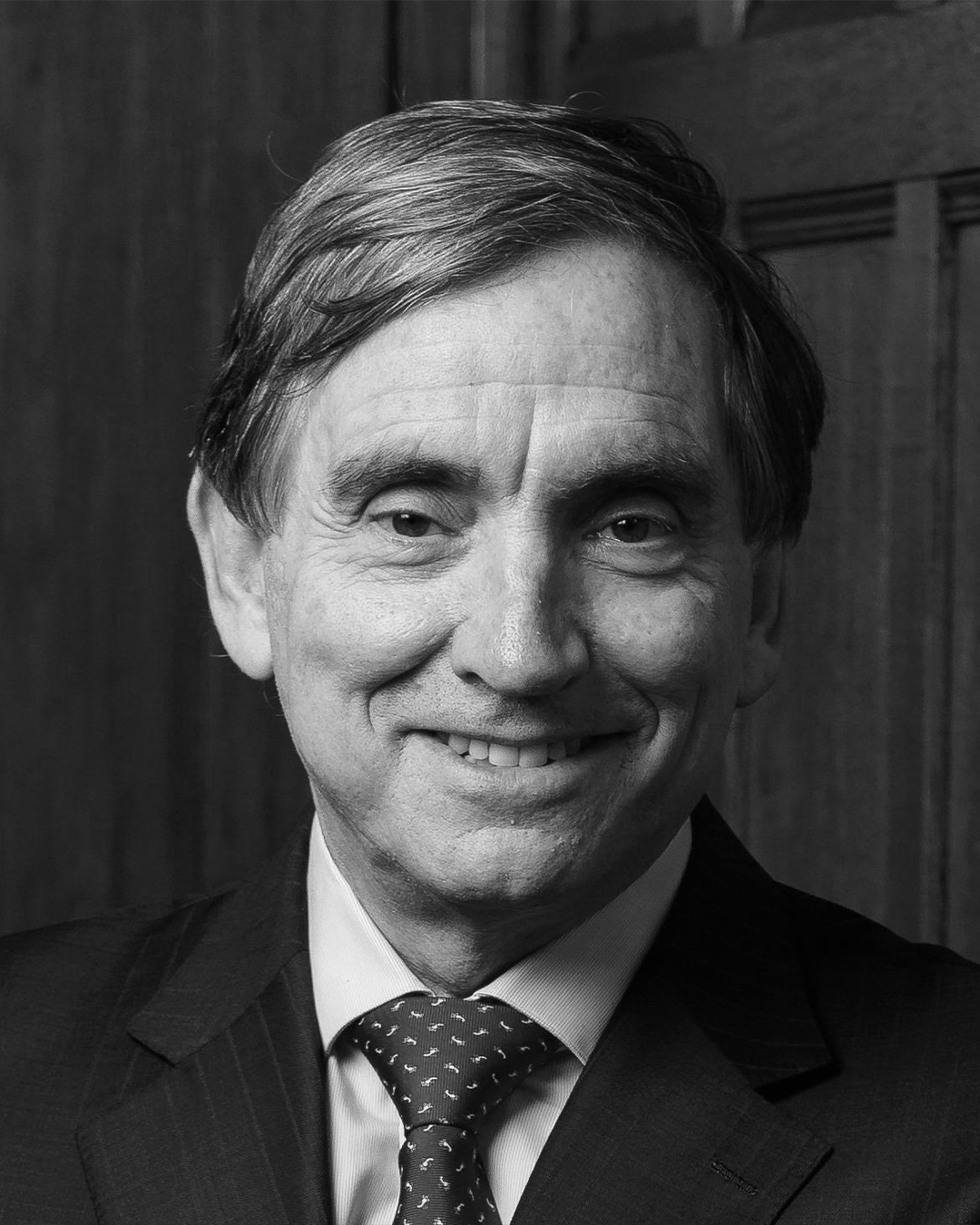 John Deanfield in black and white smiling at the camera