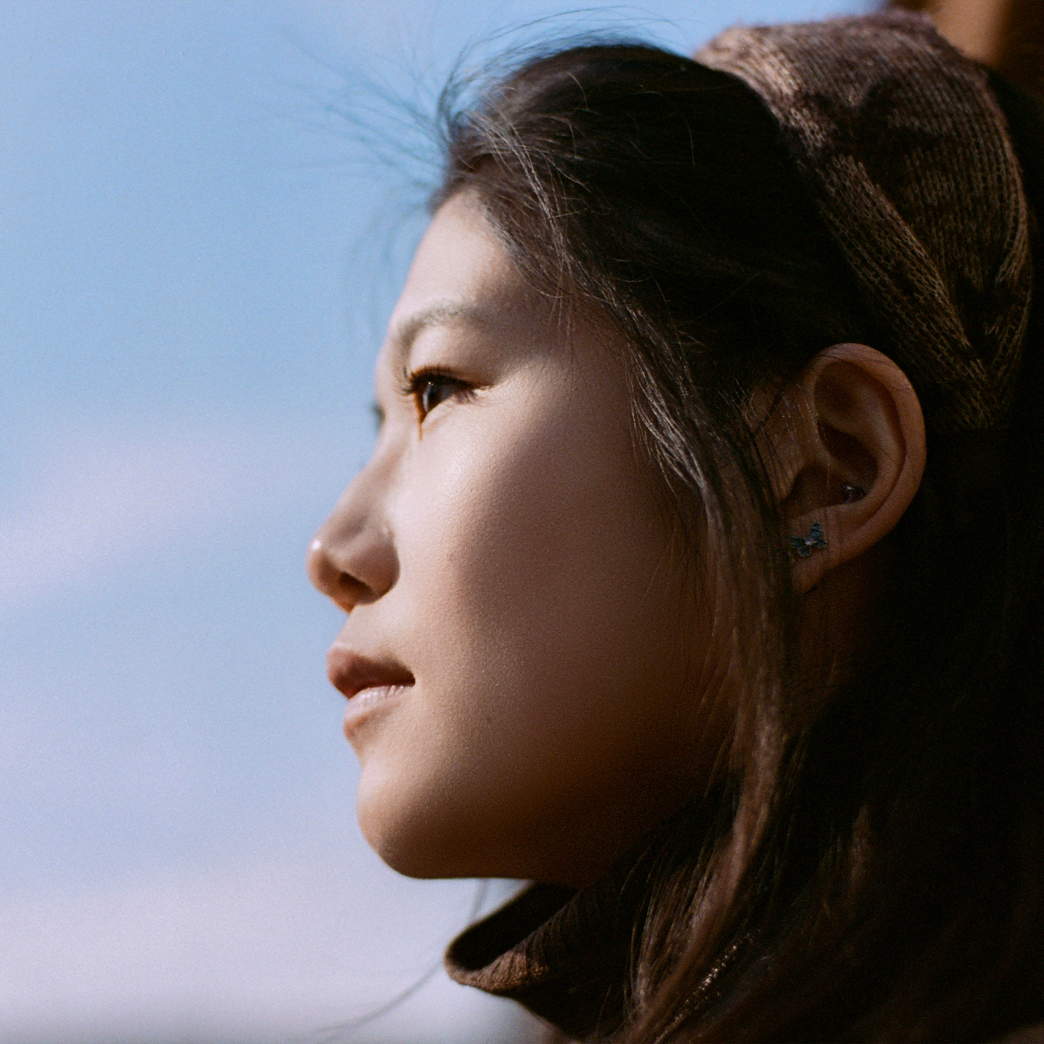 Japanese female looking away from camera with blue sky behind