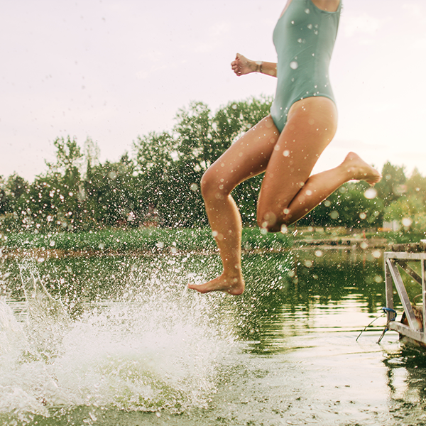 female jumping into outdoor swimming pool