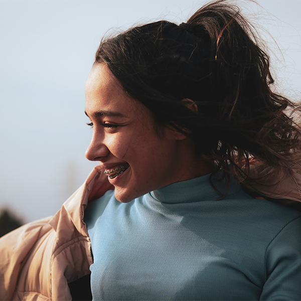 Female with sun on face smiling away from camera