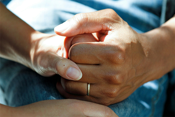 Couple holding hands on blue jeans