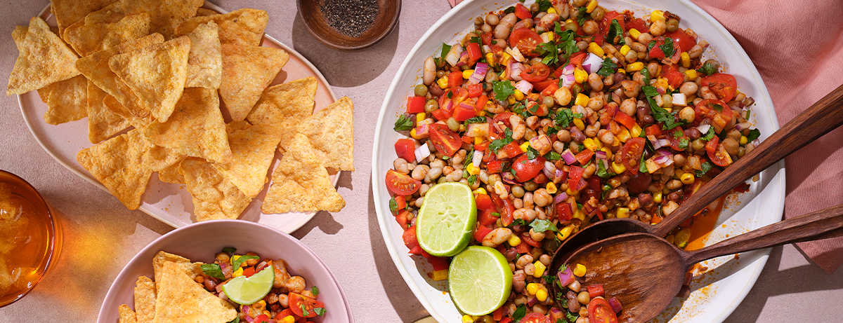 Mexican inspired mixed bean salad with tacos on a worktop