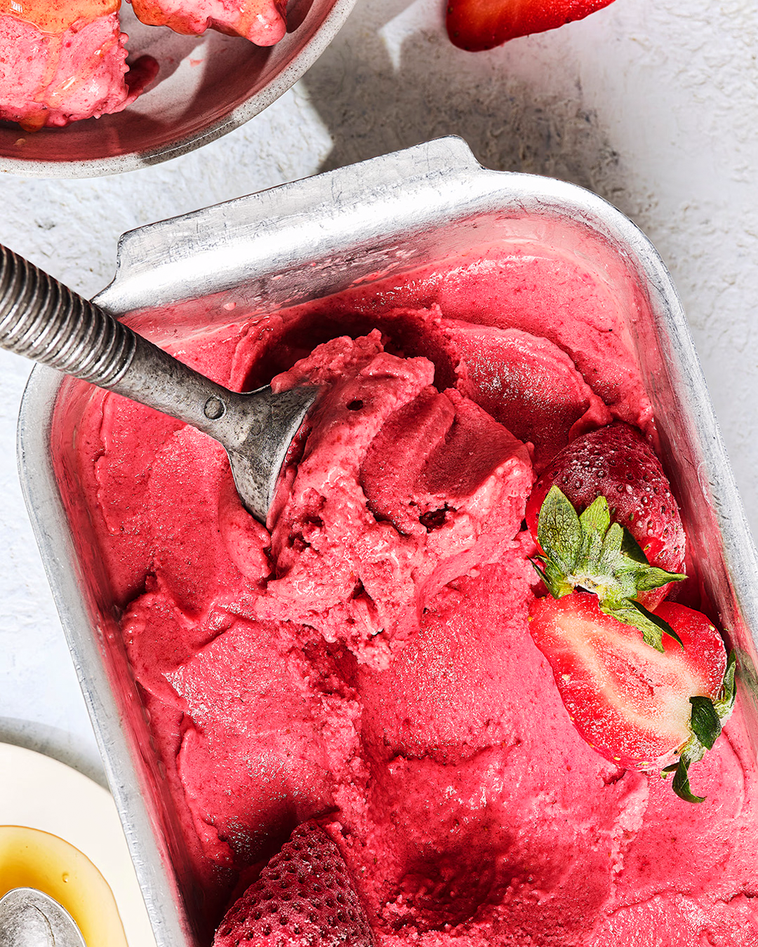 Pink ice cream with a scoop being taken out