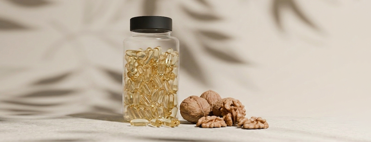 omega-3 supplements and walnuts on a beige background