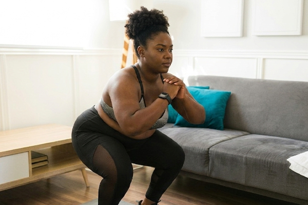 Female in living room squatting with calm expression
