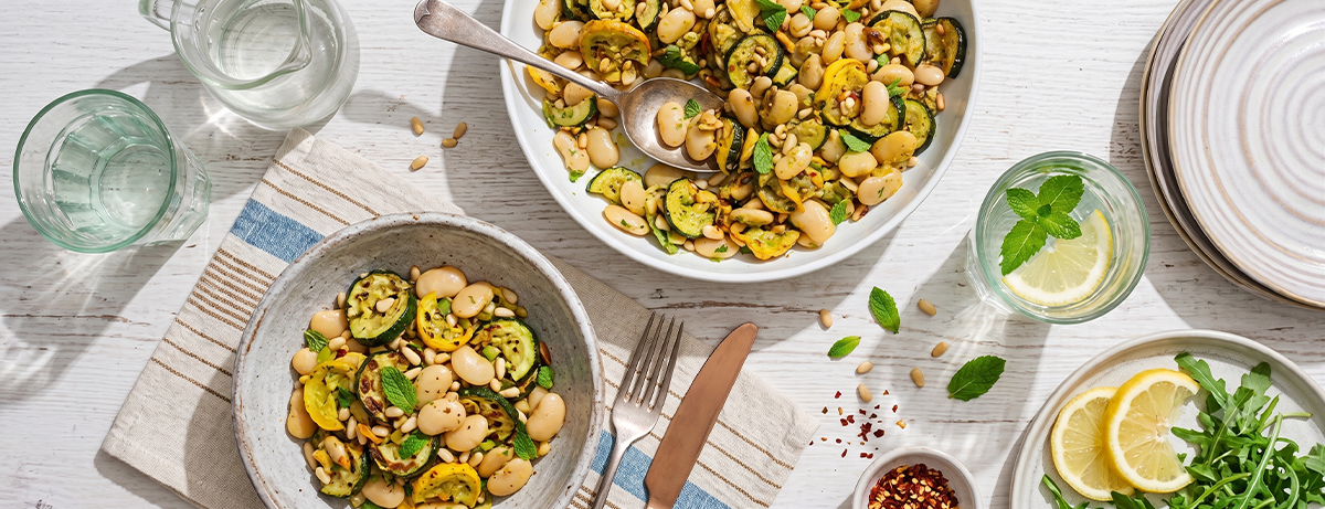 Portion of pesto and butter bean salad on kitchen background