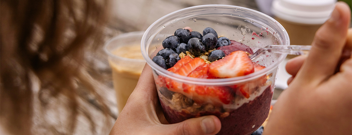 female hand holding yoghurt pot