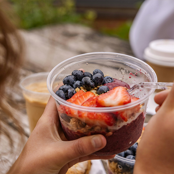 female hand holding yoghurt pot