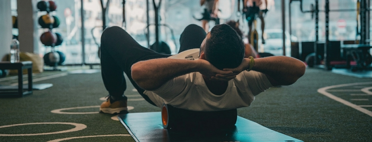 male sitting on the floor with massage roller