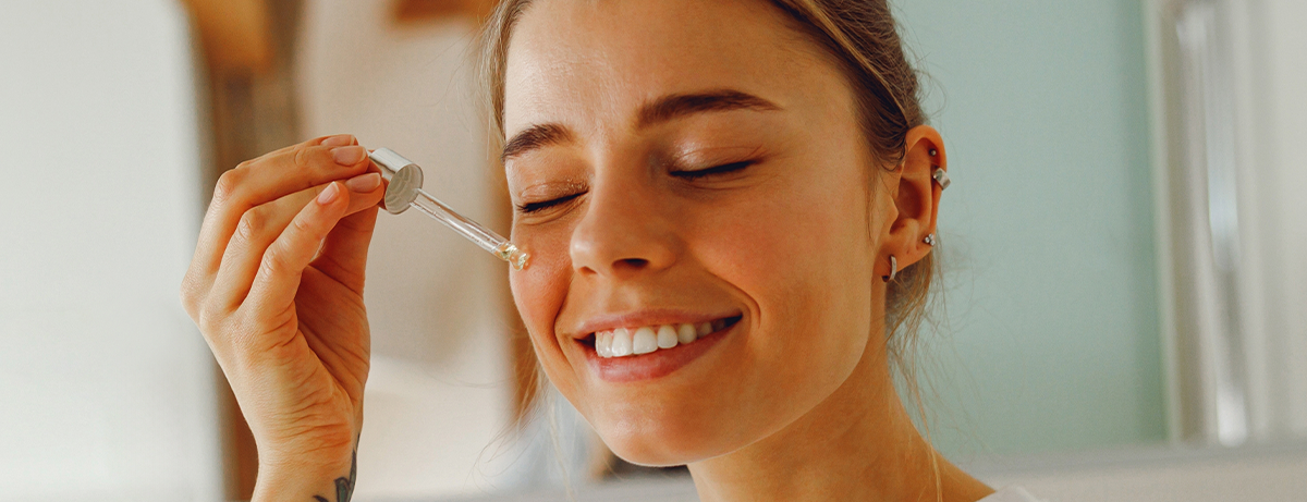 Female applying face oil to skin