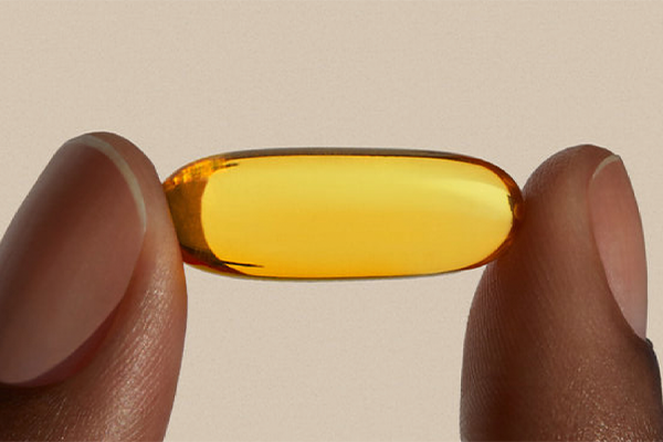 Close up of fingers holding a supplement