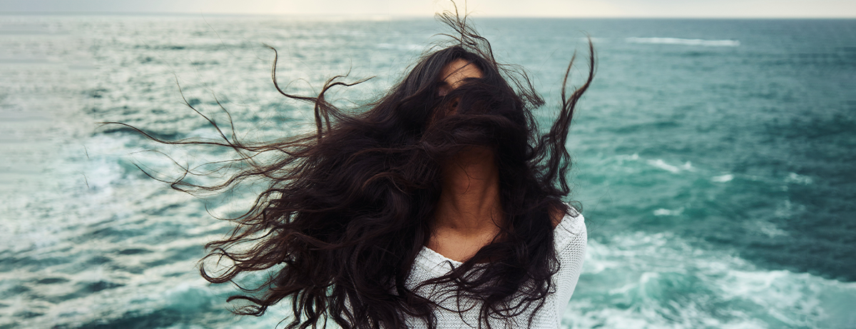 Female in front of the sea with thick hair