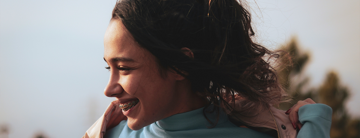 Female with sun on face smiling away from camera