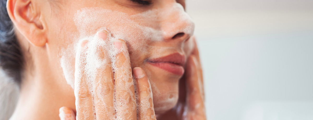 female washing face in bathroom