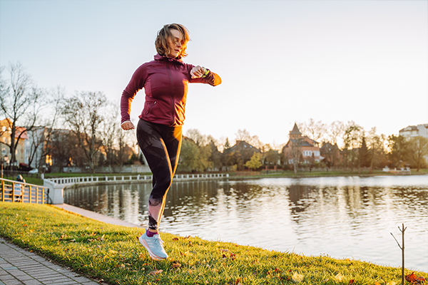 Female running around a lake in the park