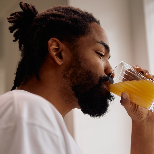 Male holding a drink in kitchen