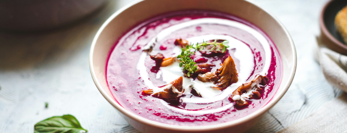 Pink soup in a bowel on a grey background