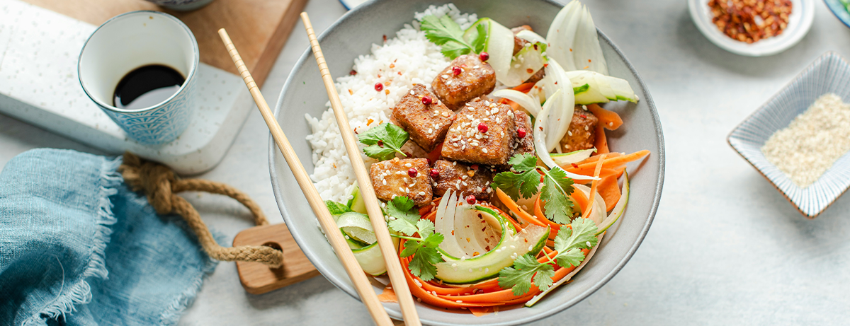 Portion of tofu stir-fry in a bowl on grey worktop