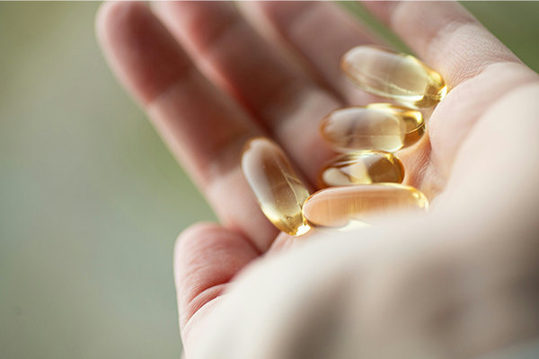 Hand close up holding vitamin-d supplements