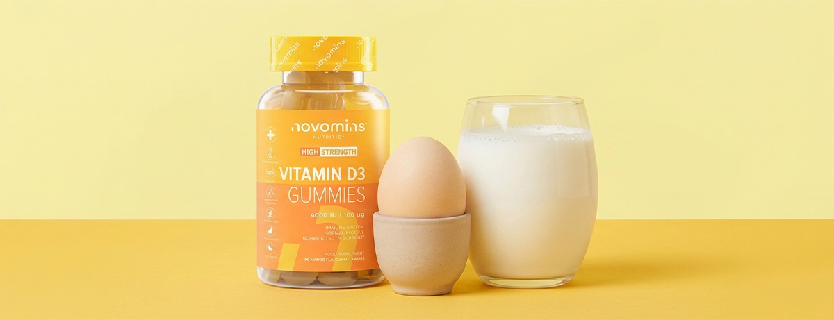 Bottle of vitamin d supps, boiled egg and glass of milk on a yellow background