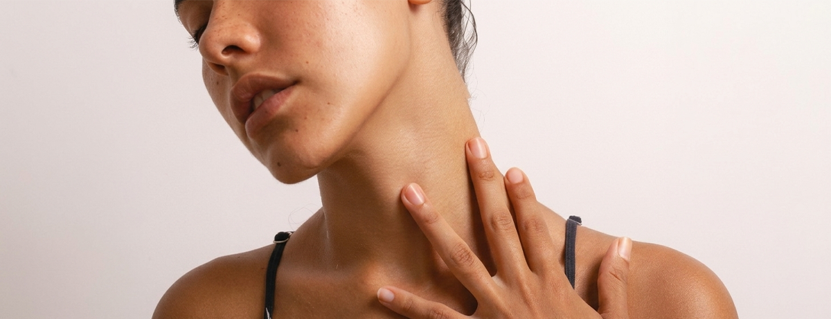 Female holding hands on neck, close up of skin