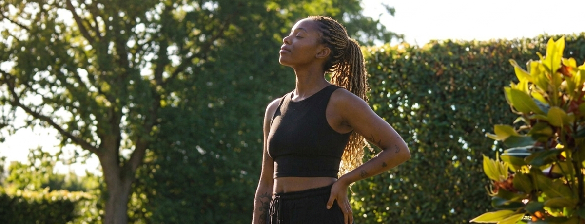 Female standing in park with fitness clothes and calm expression