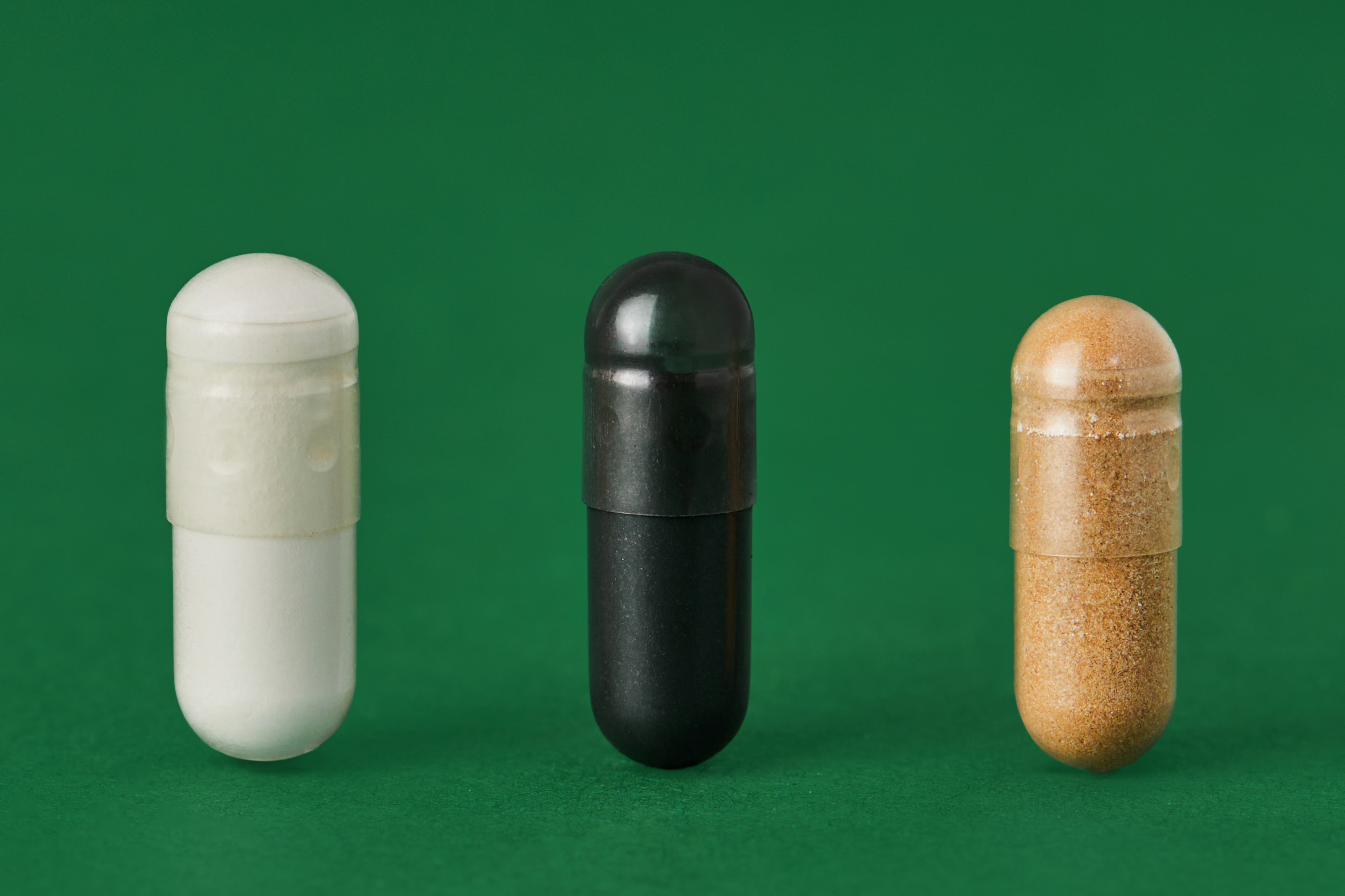 White powder contained in transparent split capsule next to black split capsule